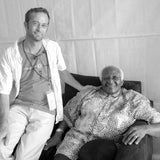 B&W photo of Stuart Alden, owner of Ink Lounge, sitting next to Desmond Tutu.